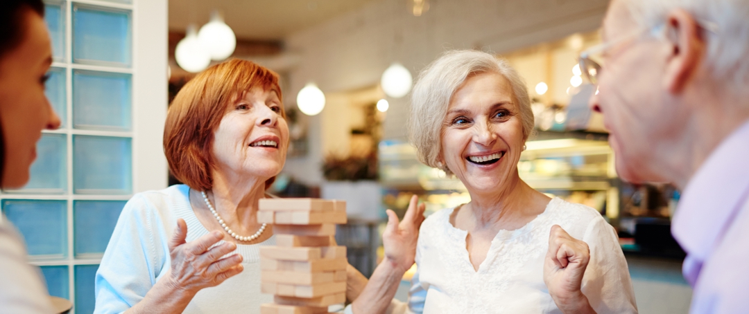 Aged friends enjoying jengs game at leisure