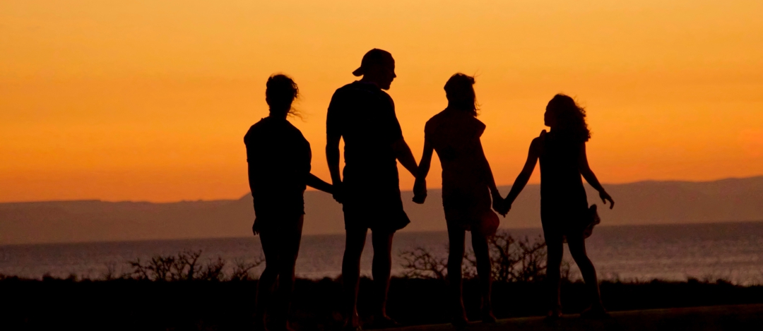 Loving the world better - people holding hands at the beach