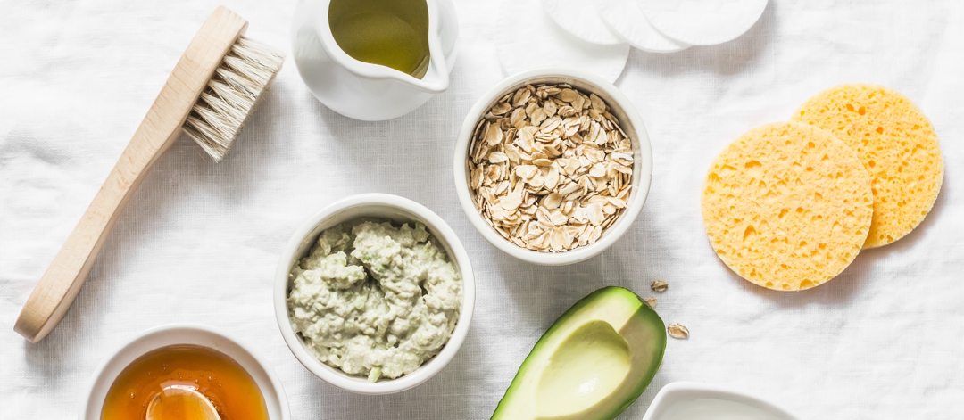 Ingredients for moisturizing, nourishing, anti-aging wrinkle face mask - avocado, olive oil, oatmeal, natural yogurt on light background, top view. Homemade beauty products concept