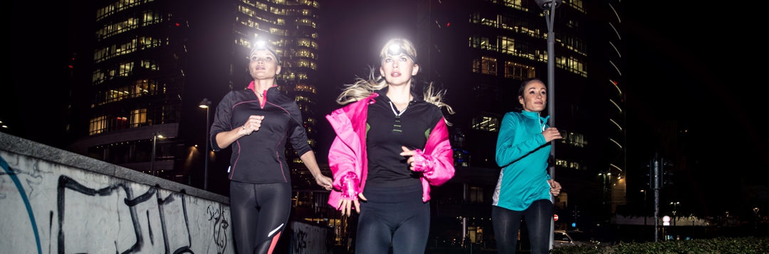 Three women running in the night in the city center