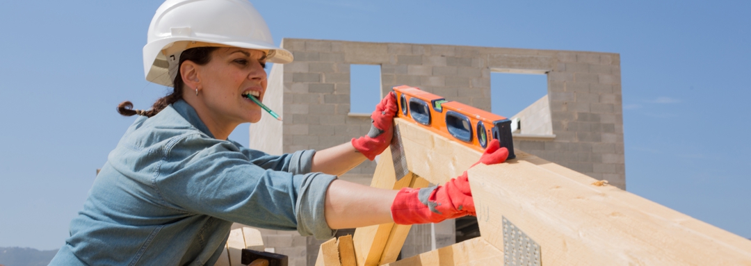 woman checking angle of roof truss at new home site