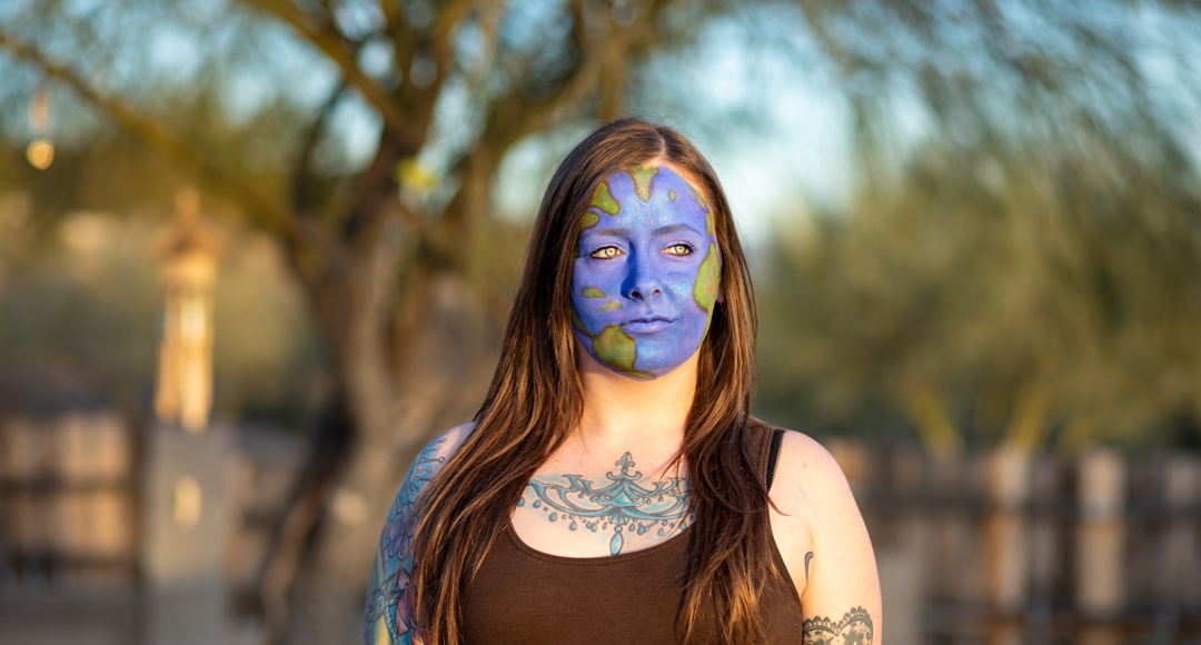 photo by Nicci Radhe - woman outdoors with earth painted on face