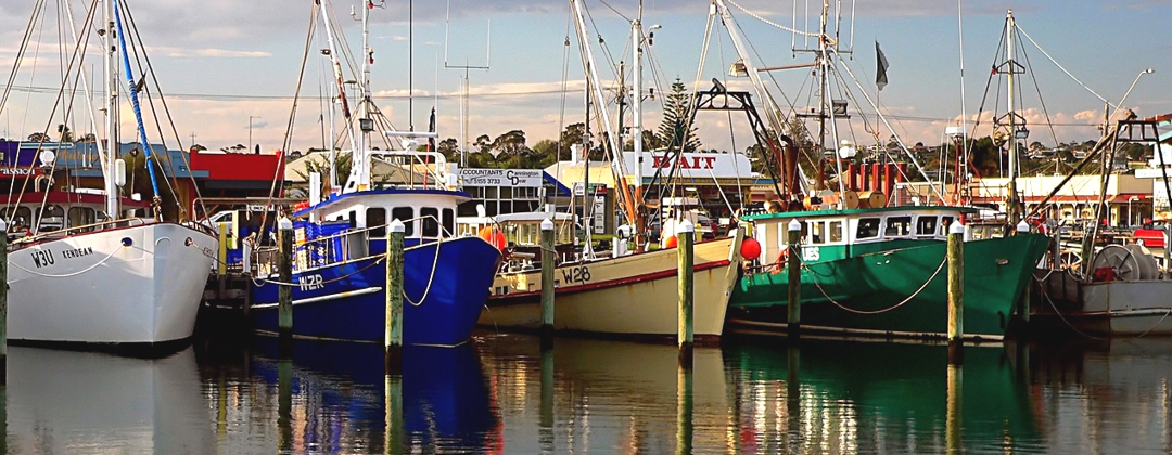 Commercial fishing boats reflecting in water