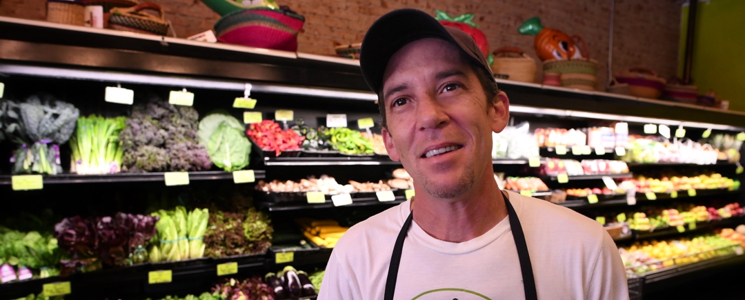 Employee in produce department inside Food Conspiracy Co-op