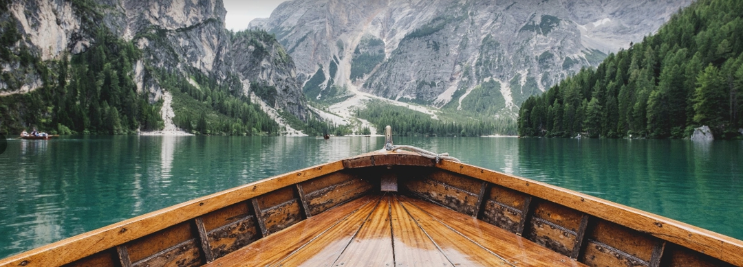 front of wooden boat on a beautiful mountain lake