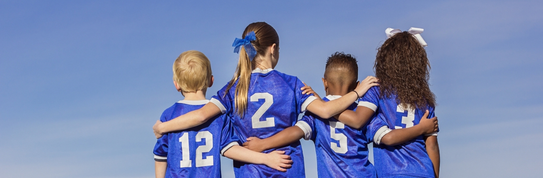 kids on a sports team with arms around each other