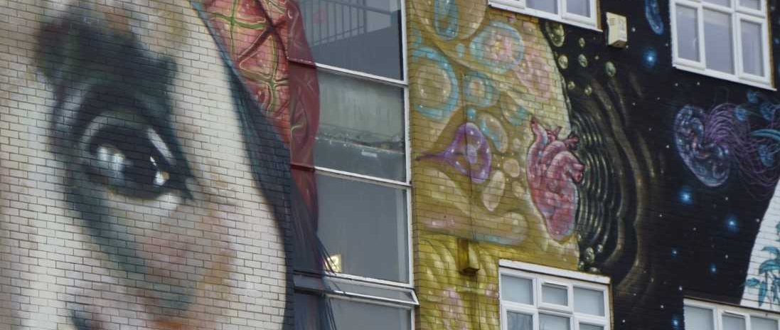 mural of Native American and graphic images painted on outside of building