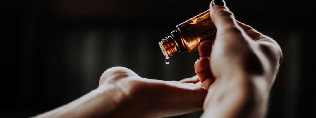 essential oil being dropped into palm of hand