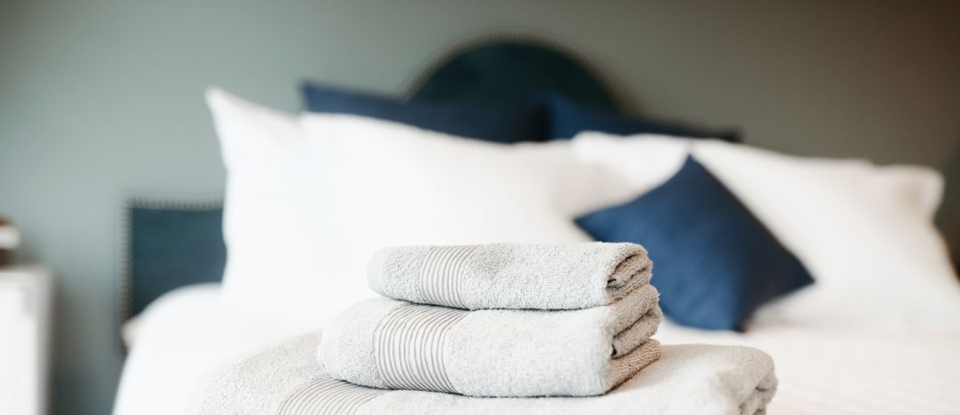 hotel room bed with pillows and towels