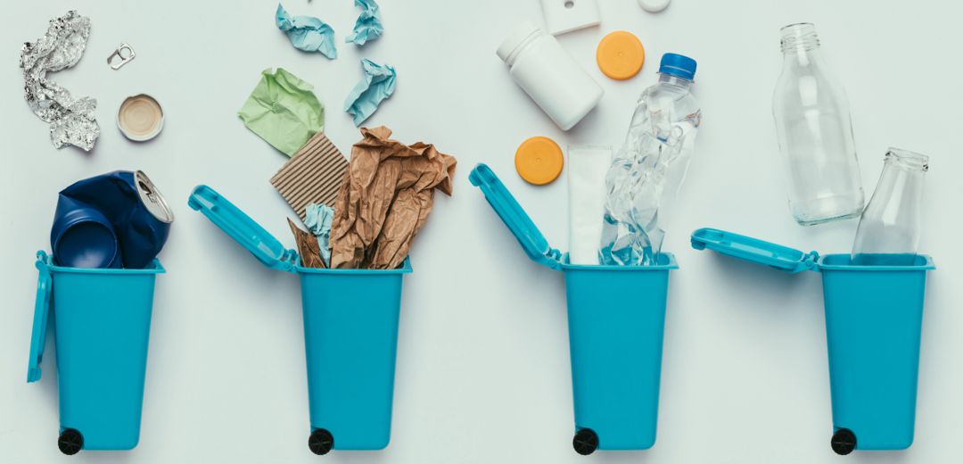 miniature trash cans lined up with lids open and various types of trash spilling out