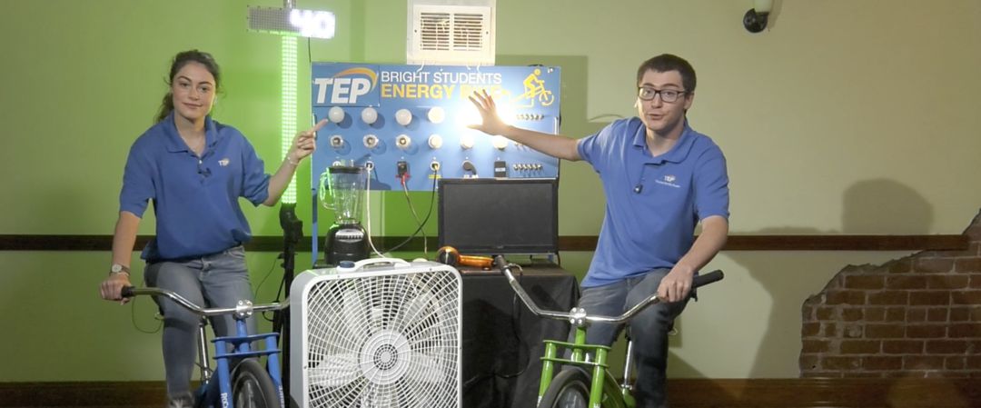 Two students on stationary bicycles, generating electricity while pedaling