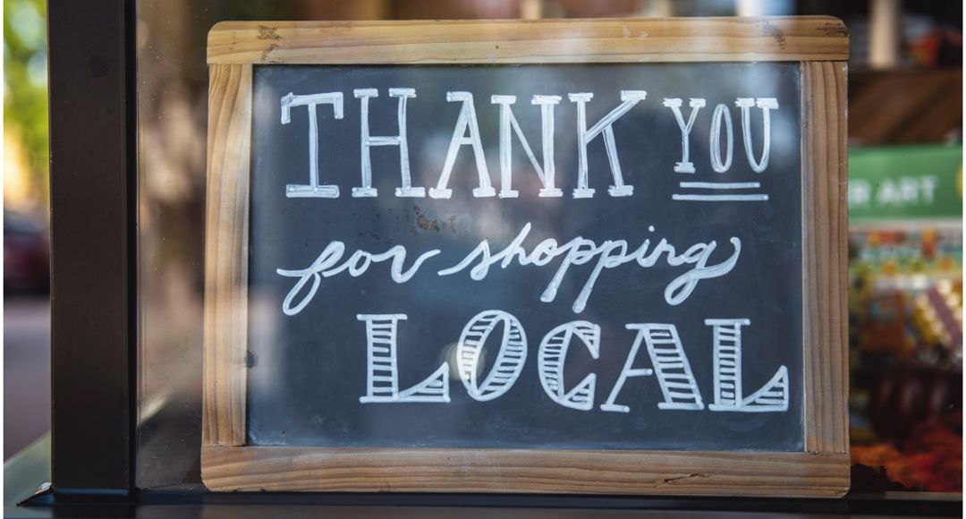 sign in window that says "thank you for shopping local"