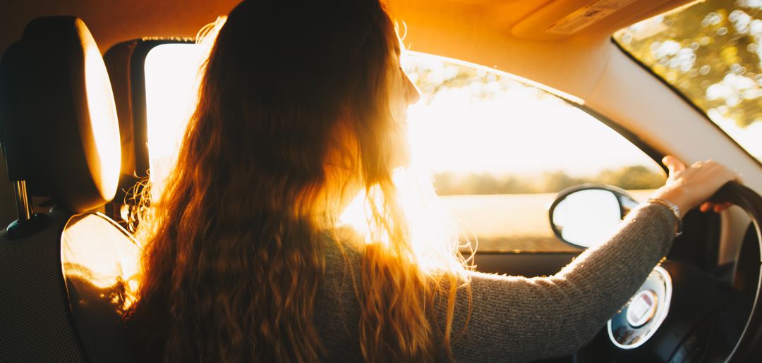 woman driving as the sun sets