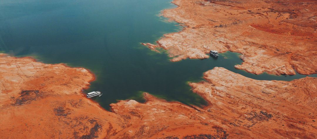 Aerial view of desert body of water with 2 house boats