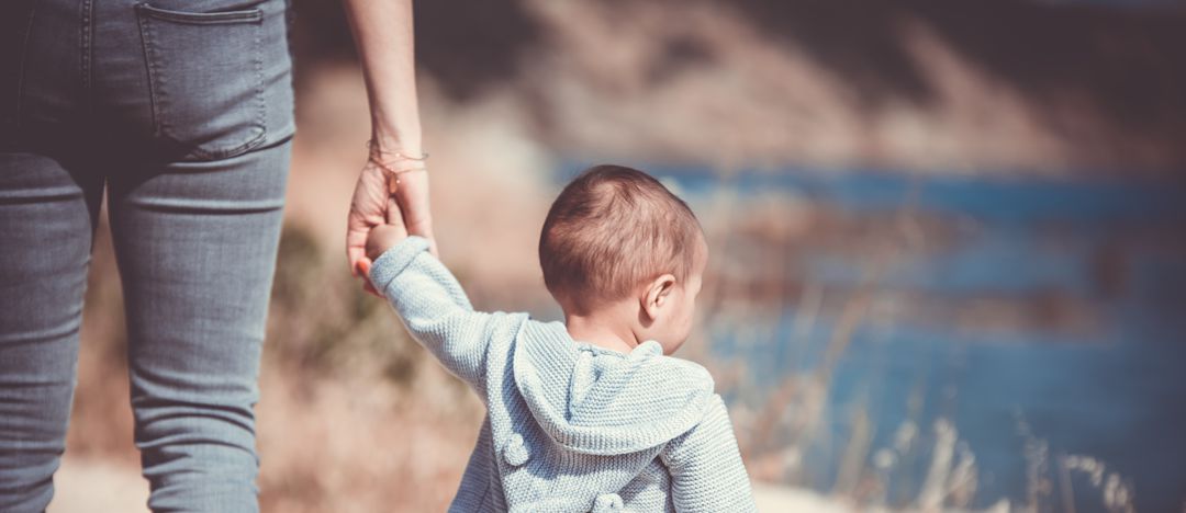 Mother and toddler walking near a body of water