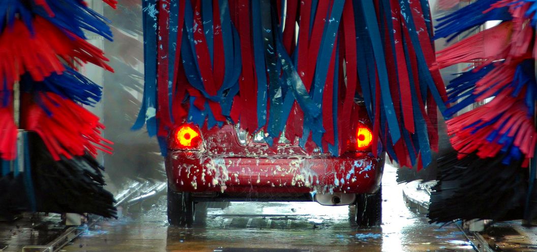 red car going through car wash