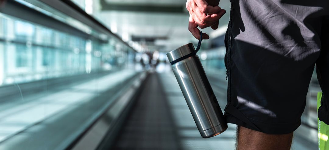 man carrying water bottle inside air conditioned building