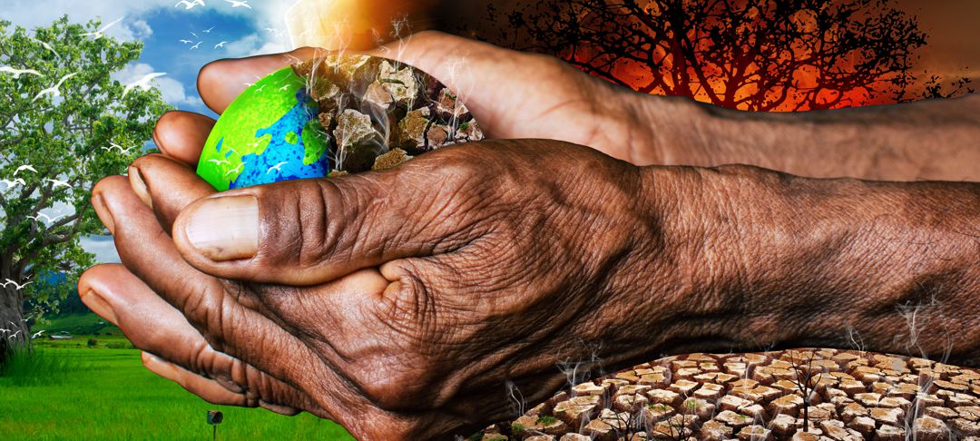 hands holding a small super imposed planet earth that is healthy on one side and dried up on the other 