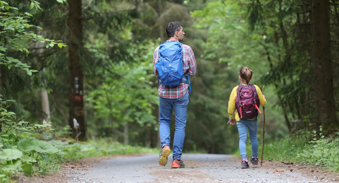 Man and little girl hiking with back packs