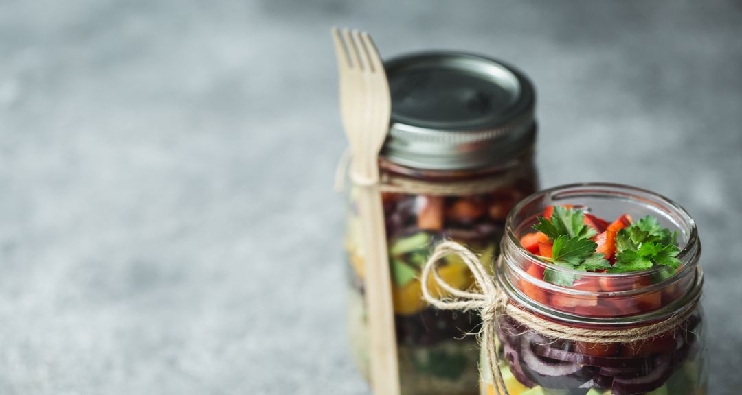 upcycled canning jars holding salad with bamboo fork