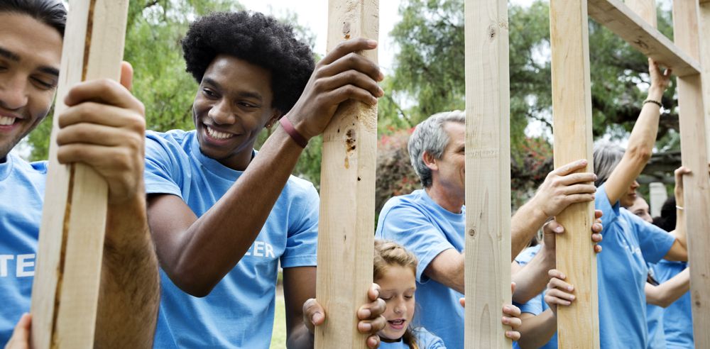 group of volunteers of mixed ethnicity and age building a home