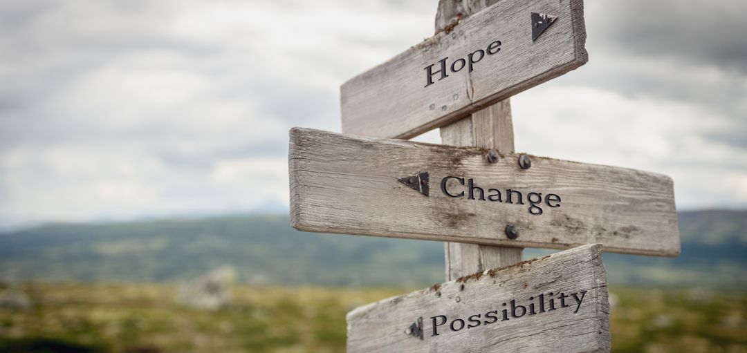 hope change possibility text engraved on wooden signpost outdoors in nature.