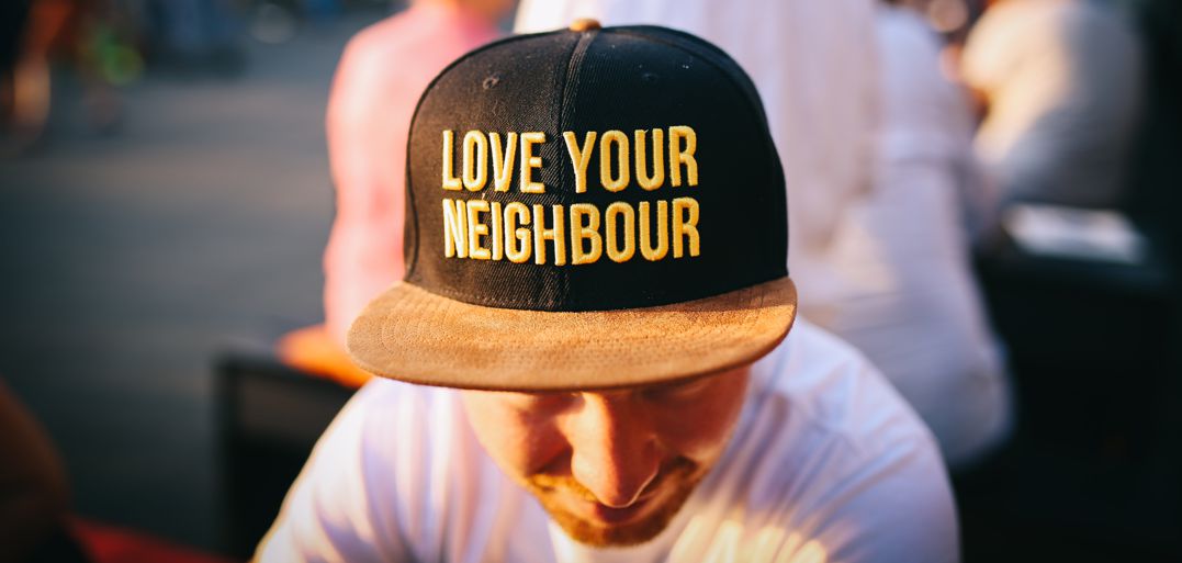 Man wearing baseball cap that says love your neighbor