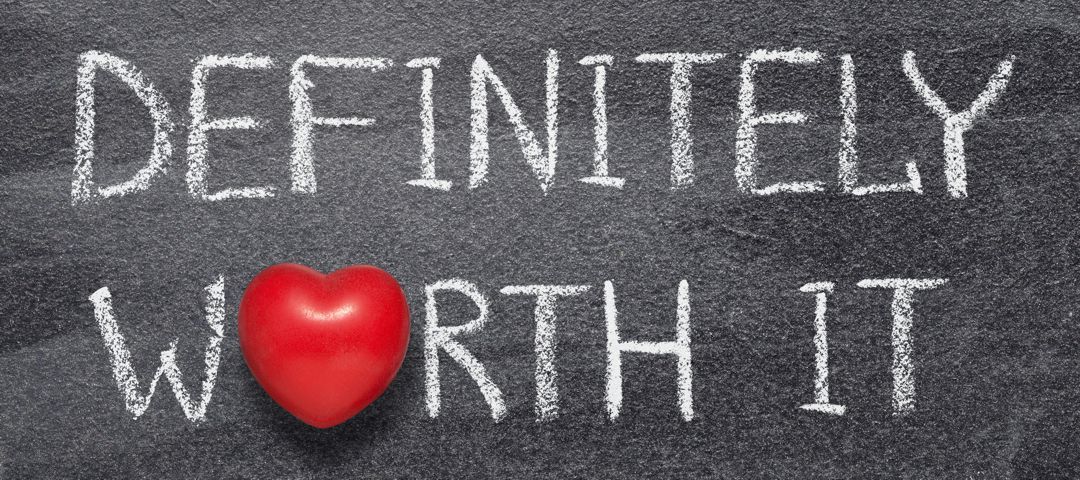 definitely worth it phrase written on chalkboard with red heart symbol