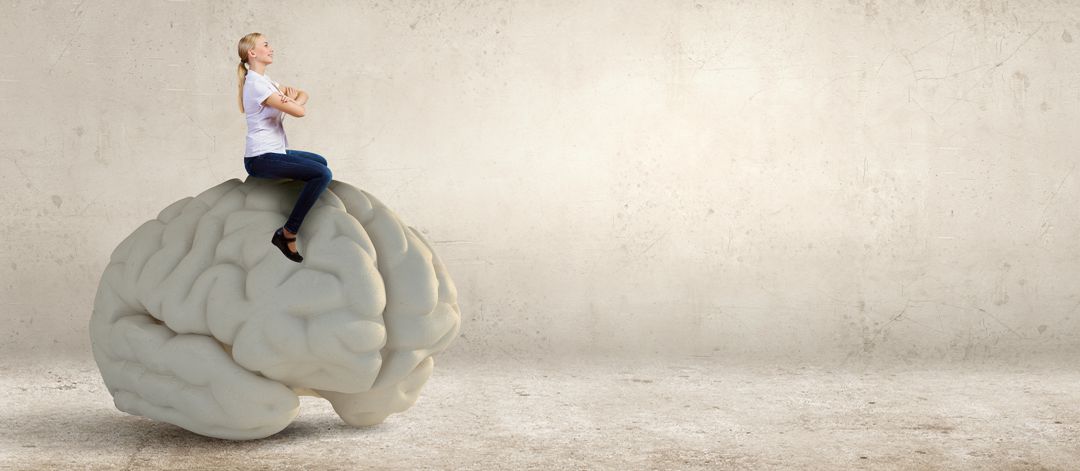 woman sitting on top of a giant grey brain