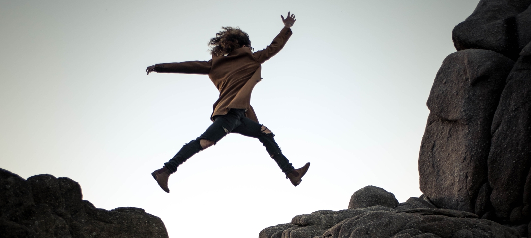 woman leaping across chasm