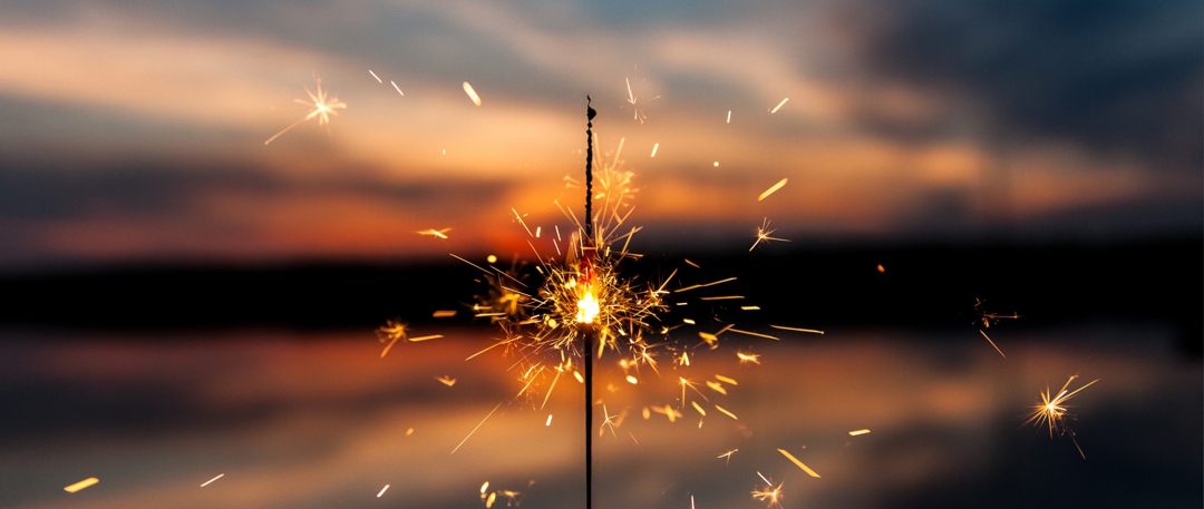 burning sparkler against sunset background